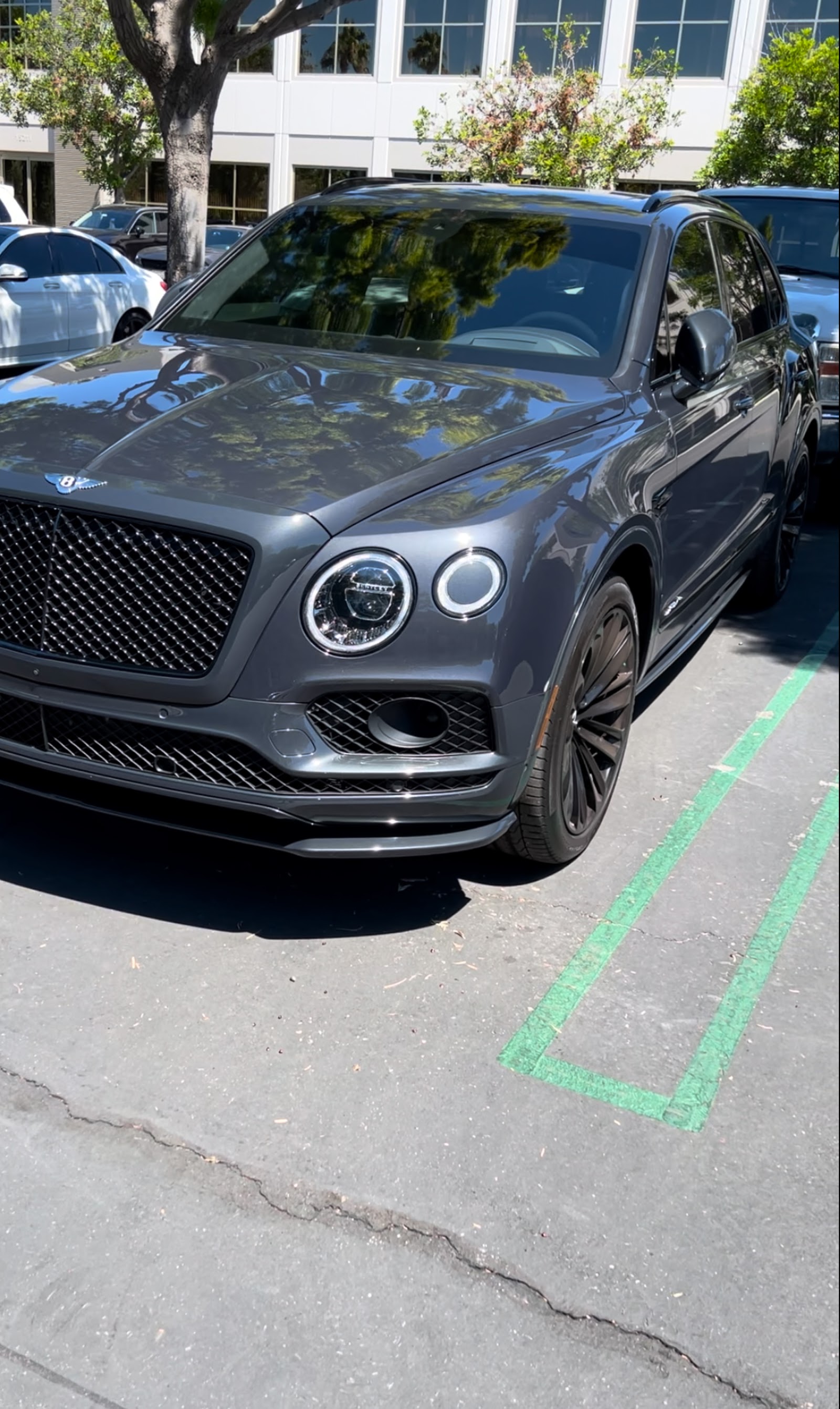Freshly detailed grey Bentley Bentayga SUV with glossy paint in parking lot